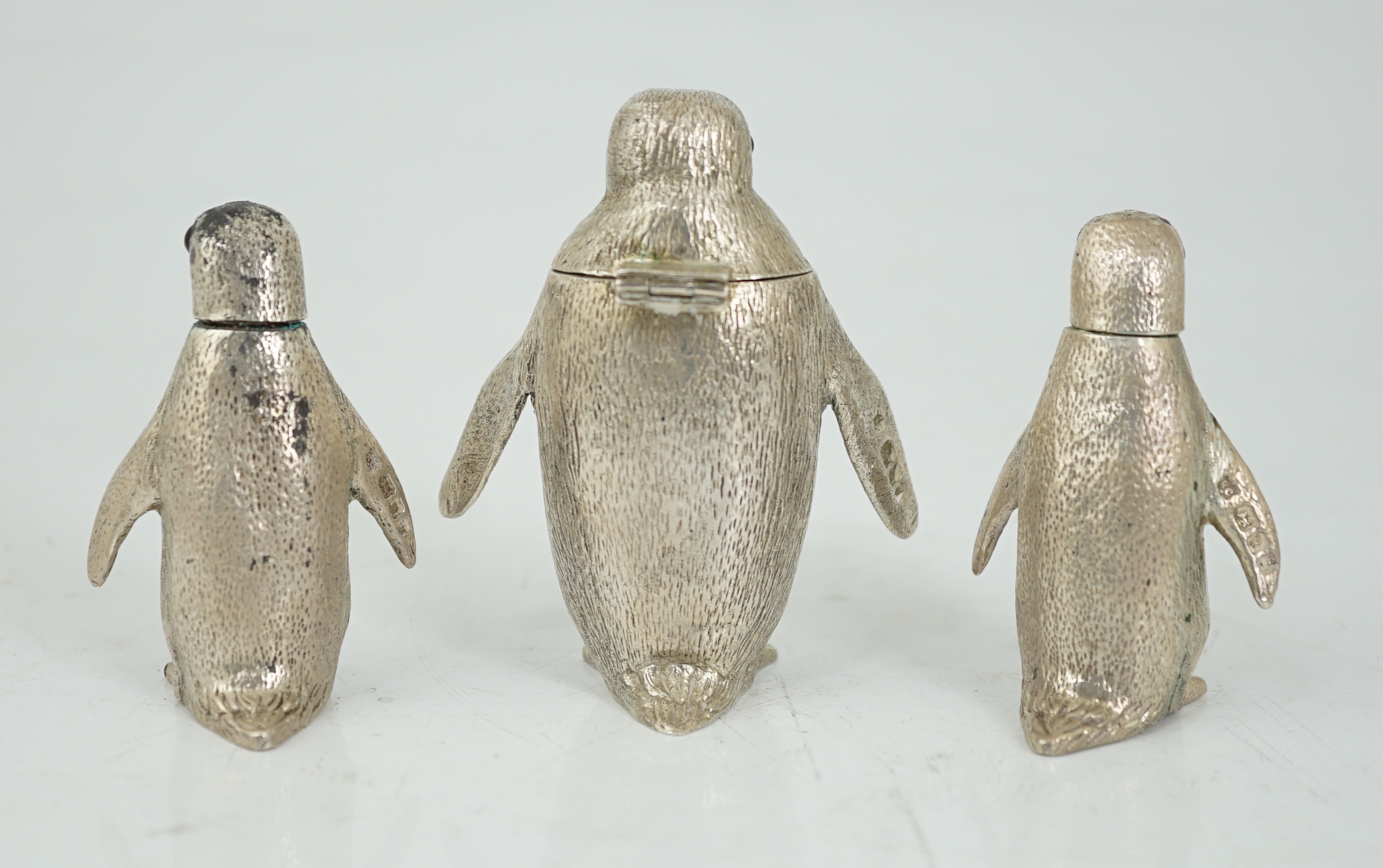 An Elizabeth II graduated suite of three novelty silver condiments, modelled as penguins, by William Comyns & Sons Ltd